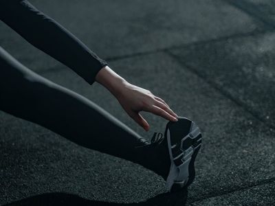 Detail of hands touching the floor in a stretch.