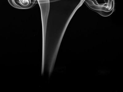 Incense smoke curling in a dark room.
