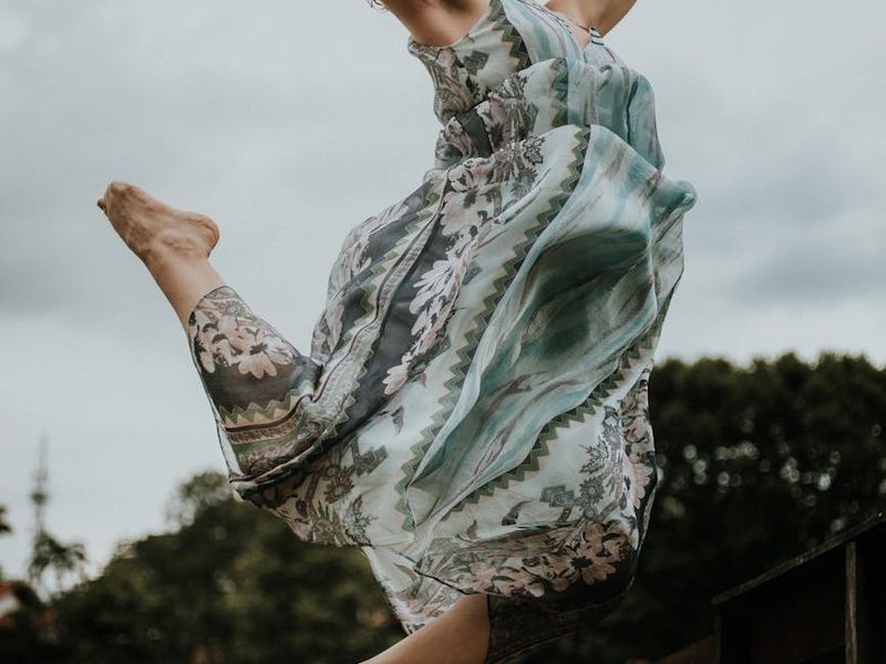 Person performing a flowing movement on a black mat.